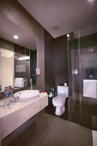 a bathroom with a sink and a toilet and a shower at favehotel LTC Glodok in Jakarta