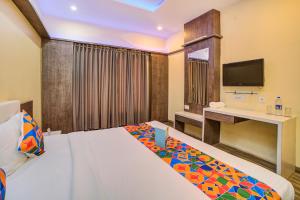 a hotel room with a bed and a television at FabHotel Bee Town in Indore