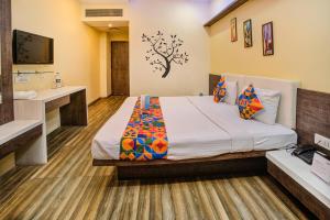 a hotel room with a bed and a television at FabHotel Bee Town in Indore
