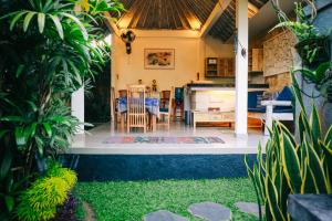 a kitchen and dining area of a house with plants at Rumah Karda Ubud in Ubud