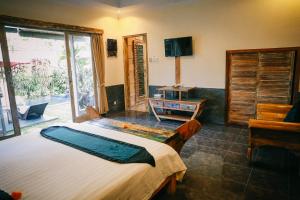 a bedroom with a bed and a tv and a window at Rumah Karda Ubud in Ubud