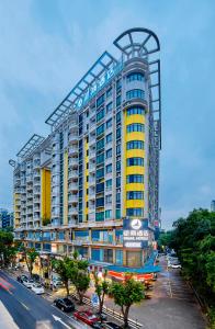 un gran edificio amarillo y azul en una calle de la ciudad en Insail Hotels (Pazhou Exhibition Center KeCun Metro Station Dunhe Road Branch Guangzhou), en Guangzhou