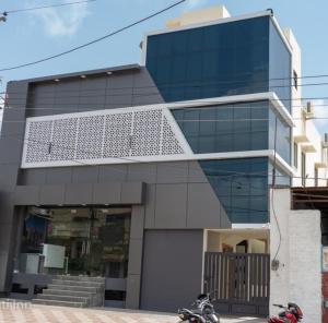 un grande edificio di vetro con due moto parcheggiate di fronte di Hotel Shanti Inn a Bikaner
