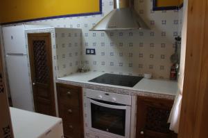 uma pequena cozinha com um fogão e um frigorífico em El Rincón Del Juez em Uña