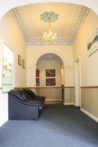 a large waiting room with a chandelier and a couch at Hobart Tower Motel in Hobart