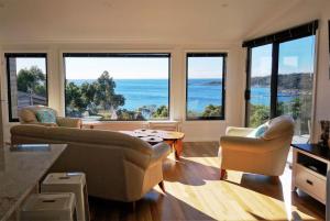 a living room with couches and a view of the ocean at THE LOFT @ Bay of Fires Seascape in Binalong Bay