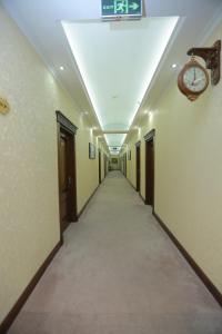 a long hallway with a clock on the wall at Hayot Hotel in Tashkent