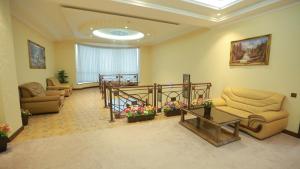 a waiting room with couches and flowers in a building at Hayot Hotel in Tashkent