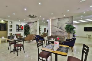 Sendan Residence في الدمام: مطعم فيه طاولات وكراسي في الغرفة