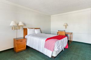 a bedroom with a bed with a red and white blanket at SUNSET INN Oklahoma City in Oklahoma City