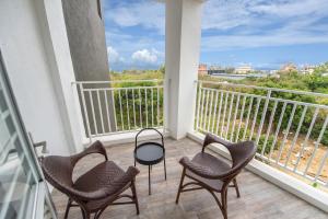 d'un balcon avec trois chaises et une vue sur l'océan. dans l'établissement Little Turkey B&B, à Île Lamay