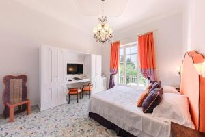 a bedroom with a bed and a desk in it at Hotel Villa Maria in Ravello