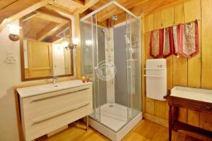 uma casa de banho com uma cabina de duche em vidro e um lavatório. em LA FARIO 2 em Gavarnie