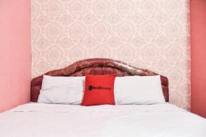 Tempat tidur dalam kamar di RedDoorz @ Pettarani Square