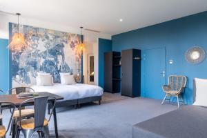um quarto de hotel com uma cama, uma mesa e cadeiras em Château de Tauzies, The Originals Relais em Gaillac