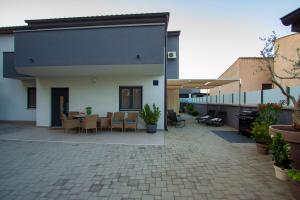 a patio with a table and chairs and a building at Apartman NeBo in Pula