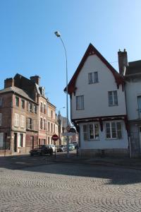 una calle adoquinada con una casa blanca y edificios en Les Capucines, en Abbeville