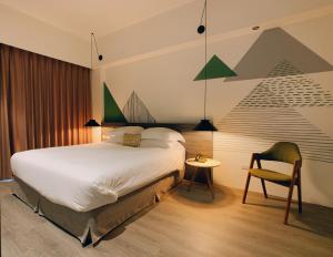 a bedroom with a large bed and a chair at Buluba in Yuanshan