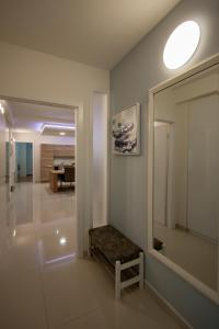 a hallway with a mirror and a bench in a room at Apartman NeBo in Pula