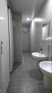 a bathroom with two sinks and a toilet and a mirror at Temple Side Hostel in Tainan +29 photos