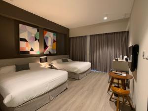 een hotelkamer met 2 bedden en een televisie bij Buluba-Green Fields in Yuanshan