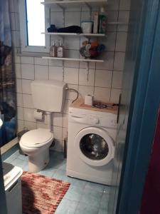 a bathroom with a toilet and a washing machine at The Best Offer in Preveza