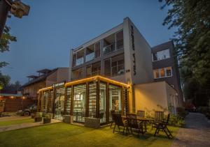 a building with a table and chairs in front of it at Villa Gréta in Siófok