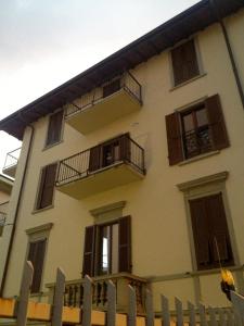 un edificio bianco con balconi e recinzione di B&B Santa Lucia a Bergamo