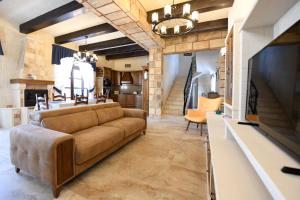 a living room with a couch and a tv at Ir- Razzett t'Indri in Qala