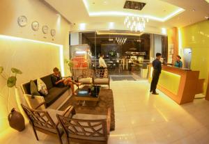 - un salon avec 2 personnes assises sur un canapé dans l'établissement Zerenity Hotel & Suites, à Cebu