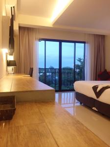 a bedroom with a large bed and a large window at The Harmony Ville in Phitsanulok