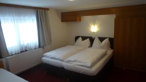 ザールバッハ・ヒンターグレムにあるPanoramaの白いシーツと窓のあるベッドのある寝室