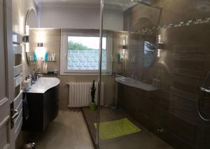 a bathroom with a shower and a sink and a glass shower at TiNat chambre in Douarnenez
