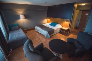 a hotel room with a bed and a table and chairs at Hotelli Seurahovi in Porvoo
