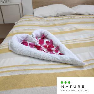 a valentines heart in a bath towel on a bed at Just nature in Novi Sad