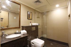 a bathroom with a sink and a toilet and a mirror at Aloha On The Ganges by Leisure Hotels in Rishīkesh