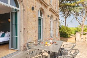 - une table et des chaises sur la terrasse d'une maison dans l'établissement Château de Tauzies, The Originals Relais, à Gaillac