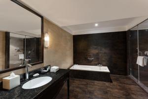 a bathroom with a sink and a bath tub at Aloha On The Ganges by Leisure Hotels in Rishīkesh