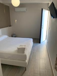 une chambre avec un lit blanc avec des serviettes dessus dans l'établissement Residenze La Villa, à Foggia 23 autres photos