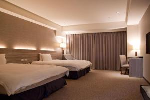 a hotel room with two beds and a television at Hotel Orchard Park - New Wing in Dayuan
