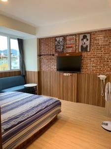 a bedroom with a bed and a flat screen tv at 埔里金宿&車站旁邊 in Puli