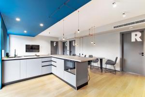 a kitchen with white cabinets and a blue ceiling at FourRoomotel in Matulji