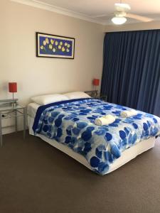 a bed room with a blue and white bedspread at Bayview Waters Apartments in Gold Coast