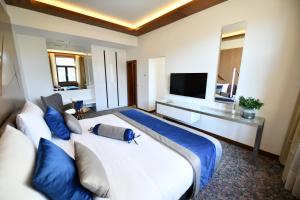 ein Schlafzimmer mit einem großen weißen Bett mit blauen Kissen in der Unterkunft Hotel Austria & Bosna in Sarajevo