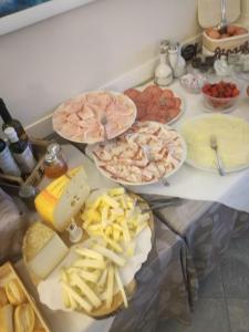 une table contenant de nombreux types de denrées alimentaires différents dans l'établissement Hotel Turandot, à Torre del Lago Puccini