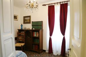 a room with a window with red curtains and a book shelf at Ca' di Ro in Camogli