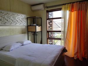 a bedroom with a bed next to a window at De Hanami Homestay @Sapphire in Cirebon