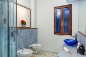 a bathroom with a toilet a sink and a mirror at Medea Residence appartamenti vacanze in Taormina