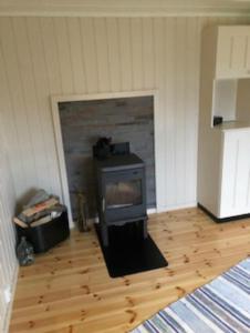 a living room with a wood stove in a room at Hamningberghuset in Havningberg