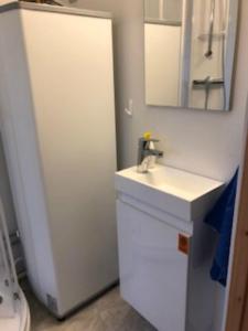 a white bathroom with a sink and a mirror at Hamningberghuset in Havningberg